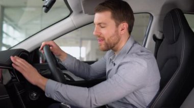 Mutlu adam bir araba galerisinden yeni bir araba almaktan memnun.