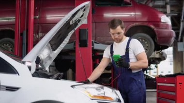 Otomobil tamircisi elleri ingiliz anahtarıyla bir araba motoru atölyesini tamir ediyor. Araba servisi ve bakım. Onarım servisi