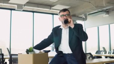 Ofisin yanındaki koridorda sinirli ve sinirli bir şekilde oturan kıdemli çalışanı işten çıkarma kutusuyla kovdu ve alkol içti. İşini ya da emekliliğini kaybetti..