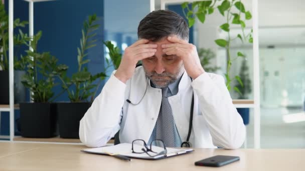 Stresat Frustrat Medic Senior Purtând Uniformă Albă Stetoscop Stând Birou — Videoclip de stoc