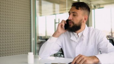 Arap doktor hastaya telefonla tavsiye veriyor.