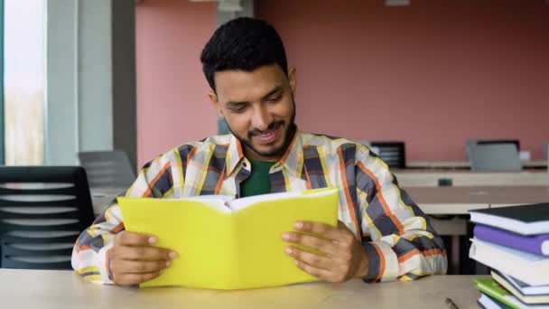 Индийский Пакистанский Студент Читает Книгу Университетской Библиотеке Подготовка Экзаменам — стоковое видео