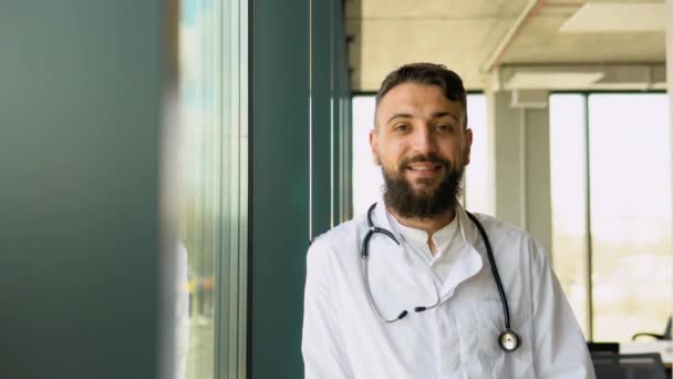 Glimlachende Jonge Arabische Mannelijke Arts Wit Medisch Uniform Tonen Een — Stockvideo