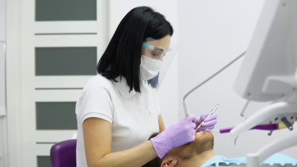 Γυναίκα Οδοντίατρος Μάσκα Προσώπου Και Γυαλιά Κάνει Θεραπεία Για Τον — Αρχείο Βίντεο