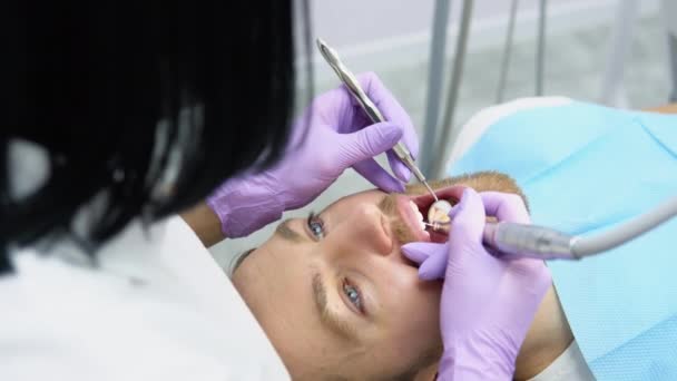 Mujer Dentista Haciendo Tratamiento Para Paciente Masculino Sosteniendo Herramientas Dentales — Vídeo de stock