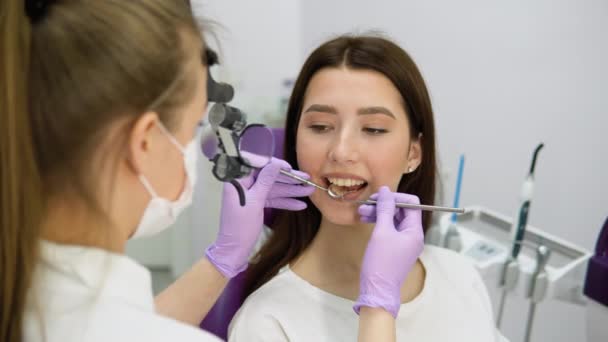 Dentista Donna Che Esamina Giovane Ragazza Guardando Denti Con Microscopio — Video Stock