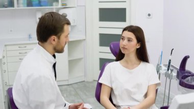 Deneyimli bir doktor genç bir kız hastayla konuşuyor. Tedavi planının tartışılması