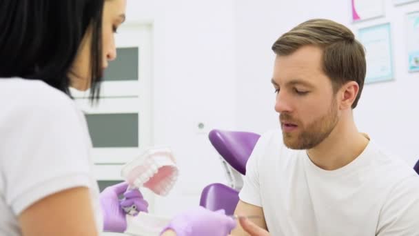 Medicul Dentist Experimentat Prezintă Model Maxilar Clinica Stomatologică Modernă Doctoriţă — Videoclip de stoc