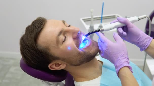 Οδοντίατρος Ξεκινώντας Λεύκανση Δοντιών Διαδικασία Νεαρό Άνδρα — Αρχείο Βίντεο