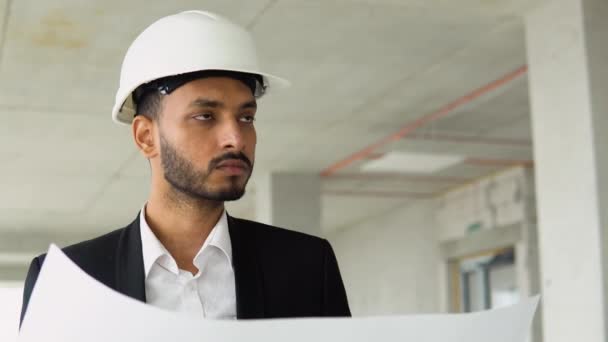 印度工程师 英俊男子或建筑师在建筑工地设计白色安全帽的建筑图则 — 图库视频影像