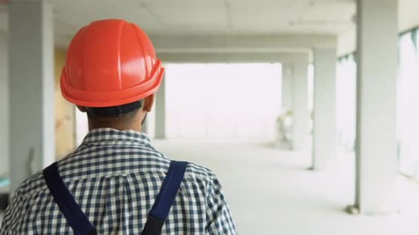 印度建筑工人 身穿制服 头戴头盔 在摩天大楼建筑工地行走 — 图库视频影像