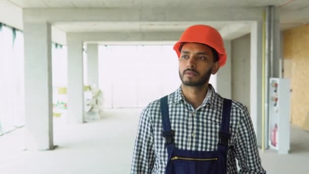印度建筑工人 身穿制服 头戴头盔 在摩天大楼建筑工地行走 — 图库视频影像