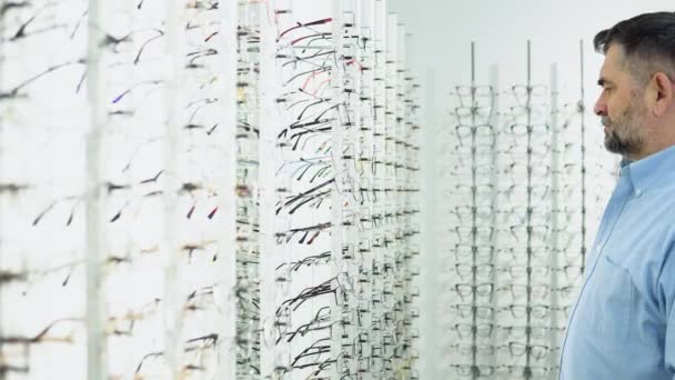 Senior Mann Wählt Brille Modernem Optikgeschäft — Stockvideo