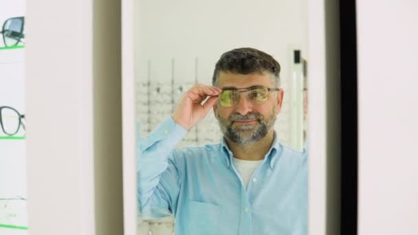 Uomo Anziano Barbuto Che Sceglie Nuovi Occhiali Negozio Ottico Guardando — Video Stock