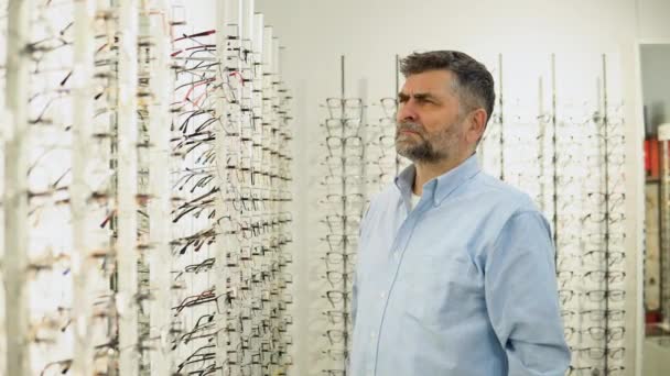 Старший Мужчина Выбирает Очки Современном Оптическом Магазине — стоковое видео