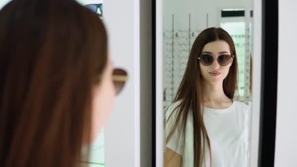 Πορτρέτο Της Όμορφης Νεαρής Γυναίκας Που Επιλέγει Γυαλιά Ηλίου Στο — Αρχείο Βίντεο
