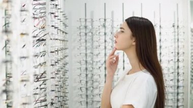 Kadınlar gözlüğü seçer. Bir sıra gözlük optikte. Gözlük dükkanı. Optik mağazasında gözlüklü dur. Görme düzeltmesi