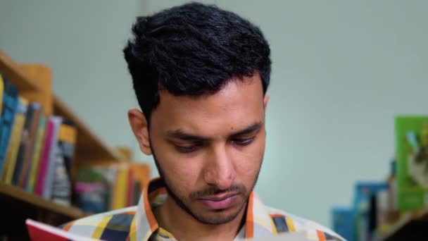 Серйозно Задуманий Індійський Студент Чоловічої Статі Читає Книгу Бібліотеці — стокове відео