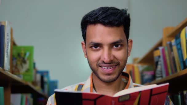 Glückliche Indische Männliche Studenten Lesen Ein Buch Der Bibliothek — Stockvideo