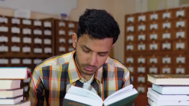 Giovane Studente Indiano Che Legge Libro Con Una Faccia Seria — Video Stock