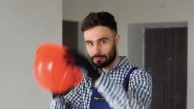 Tamirci koruyucu bir kask takar. Bir apartman dairesinde ya da ofiste onarım.