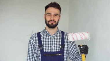 Pozitif insan yapımı işçinin portresi ve boya silindiri. Apartmanda tamirat yapılıyor..