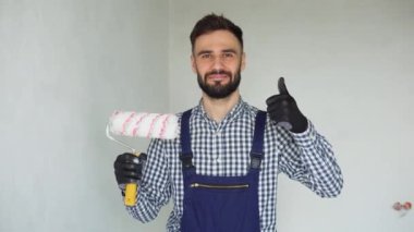 Pozitif insan yapımı işçinin portresi ve boya silindiri. Apartmanda tamirat yapılıyor..