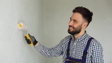 Duvarları boyayan genç bir işçi.
