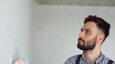 Duvarları boyayan genç bir işçi..