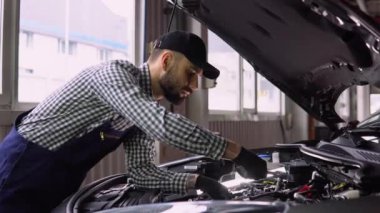 Araba Servisi, tamir, bakım ve insan kavramı - otomatik mekanik adam atölyesinde çalışan lambalı.