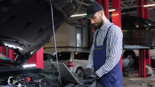 Mecânico Experiente Uniforme Está Usando Laptop Durante Reparação Carro Auto — Vídeo de Stock