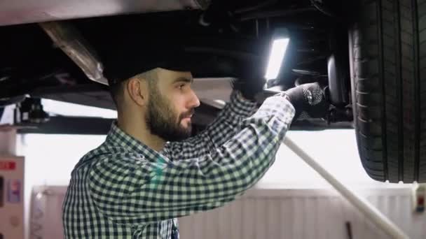Profesional Mecánico Automóviles Trabajando Bajo Coche Levantado Servicio Reparación Automóviles — Vídeos de Stock