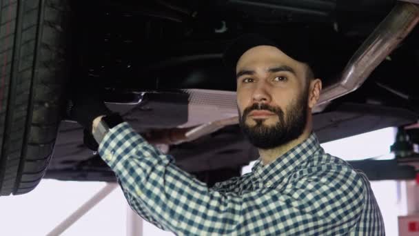 차고에서 승강기 밑에서 일하는 자동차 정비사들 — 비디오
