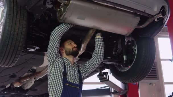 Mechanika Samochodowa Pracująca Pod Samochodem Podnośniku Hydraulicznym Garażu — Wideo stockowe