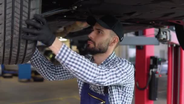 Mechanika Samochodowa Pracująca Pod Samochodem Podnośniku Hydraulicznym Garażu — Wideo stockowe