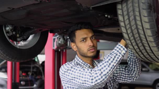 Індійський Автомеханік Працює Під Машиною Гідравлічному Ліфті Гаражі — стокове відео