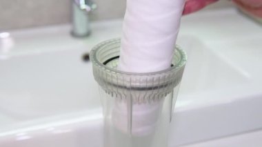 Tesisatçı ya da tamirci banyoya yeni bir saf beyaz su filtresi koyuyor.