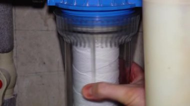 Tesisatçı temiz ters osmoz su filtresini değiştiriyor..