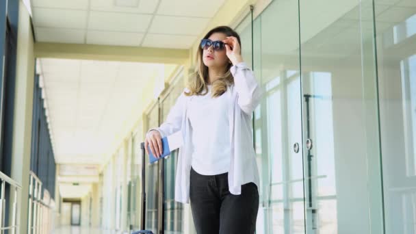 戴着太阳镜 手持护照和登机证的妇女在机场走廊等待证件管制 — 图库视频影像