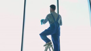 Alışveriş merkezinin camlarını silen pencere temizleyicisi..