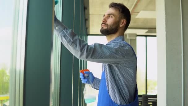 男性の専門的な清掃サービス労働者は 特別な設備を備えた店の窓や店の窓を掃除します — ストック動画