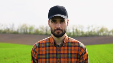 Yeşil tarım alanındaki genç çiftçinin portresi.