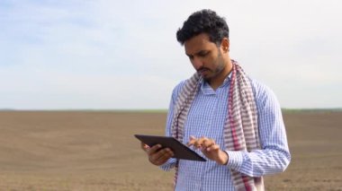 Hintli çiftçi tohum ekmeden önce toprak kalitesini kontrol ediyor ve sonuçları tablete yazıyor. Tarım, bahçıvanlık veya ekoloji kavramı.