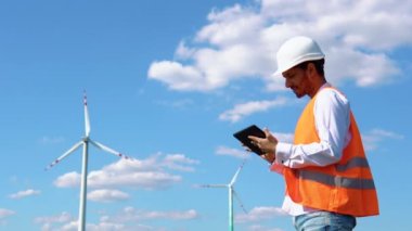 Mühendis rüzgar türbini sistemini tabletle kontrol ediyor. Alternatif Enerji. Rüzgar çiftliği