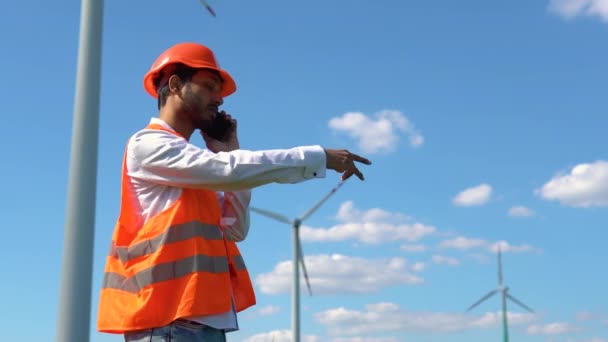 電話で話している風力発電所の隣にインドのエンジニア 再生可能エネルギー技術をきれいにする 風力発電所 — ストック動画