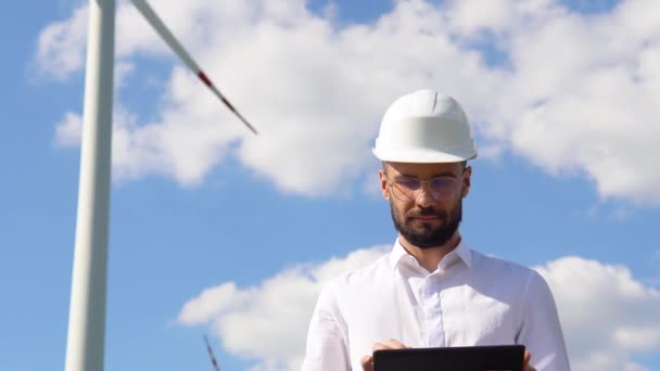 工程师与平板在风车农场工作产生的电力清洁能源 拉丁工程师检查控制电力 采用替代绿色能源的风力涡轮机发电机组 — 图库视频影像