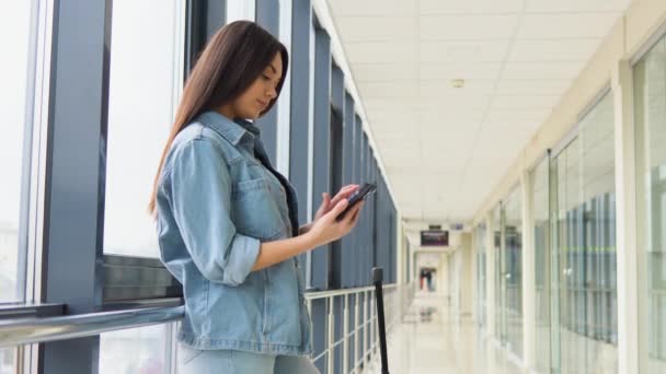 Jeune Femme Utilisant Téléphone Intelligent Dans Hall Aéroport — Video