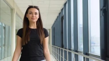 Havaalanı Terminalinde Mutlu Gülümseyen Kadın Bavuluyla Yürüyor.