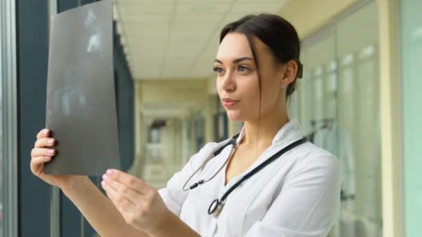 Γυναίκα Γιατρός Εξετάζει Μια Ακτινογραφία Της Σπονδυλικής Στήλης Των Προσώπων — Αρχείο Βίντεο