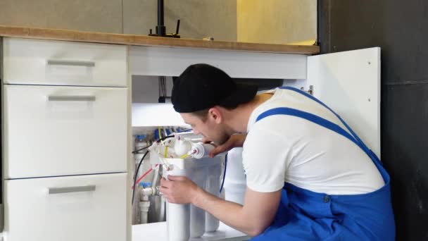 管道工安装或更换水过滤器 替换水产过滤器 修理工在厨房里安装滤水筒 反渗透净水系统的安装 — 图库视频影像